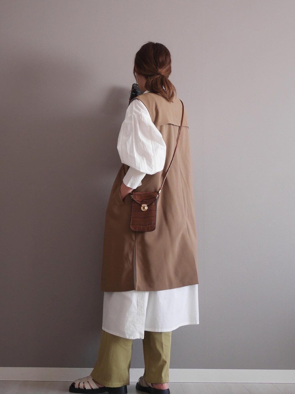 ホワイト系のシャツワンピース、グリーン系のスラックス、ブラウン系のノーカラージャケットを着用したレディースの春コーディネートの2枚目の写真