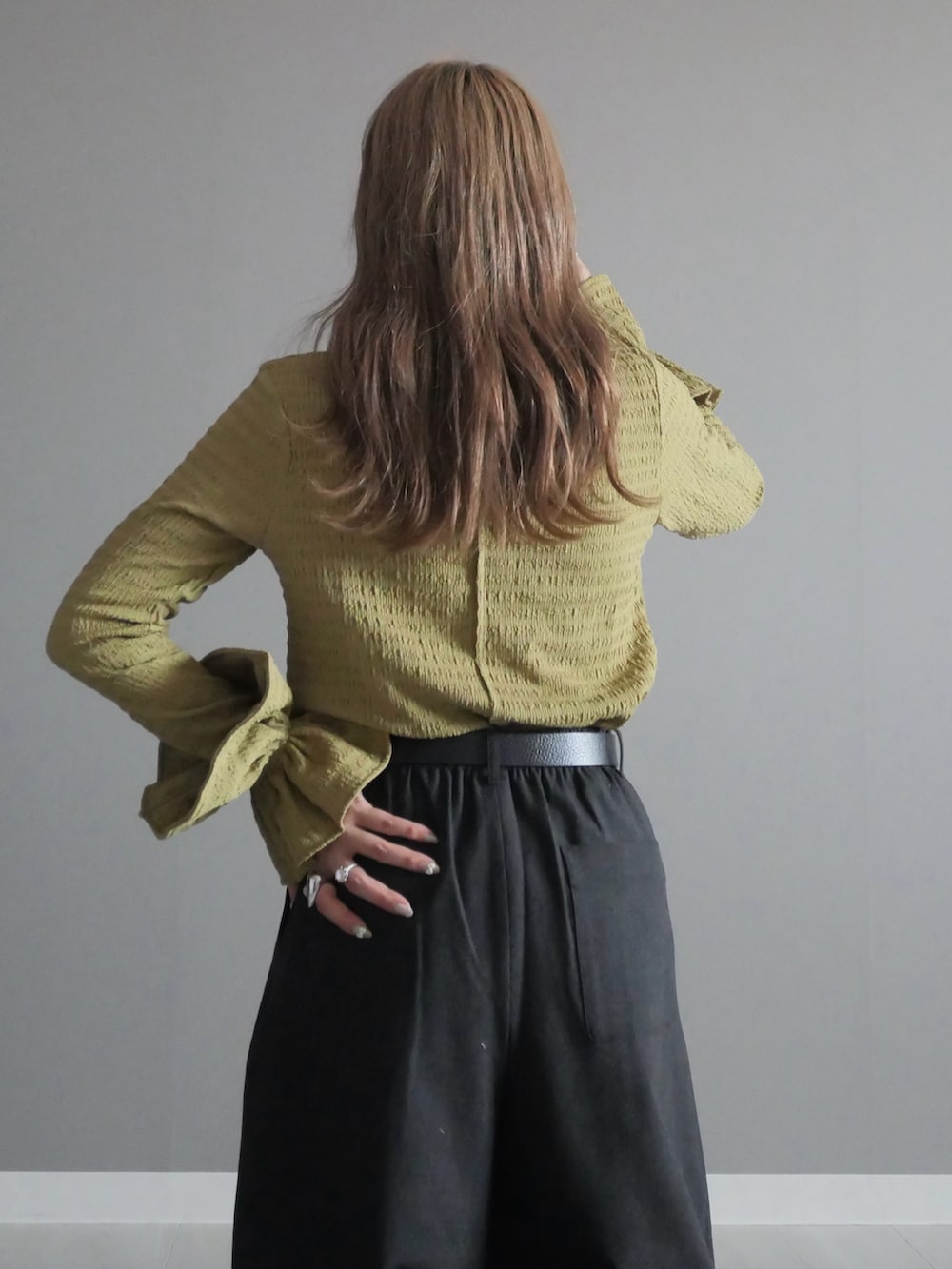 ブラック系のトートバッグ、グリーン系のTシャツ/カットソー、ブラック系のブーツを着用したレディースの秋コーディネートの4枚目の写真