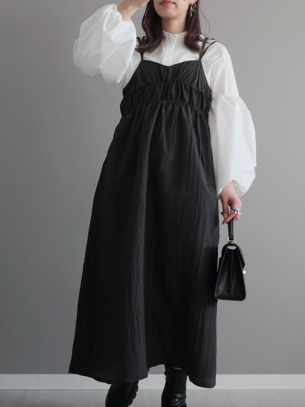 ブラック系のトートバッグ、ブラック系のブーツ、ホワイト系のシャツ/ブラウスを着用したレディースの春コーディネートの2枚目の写真