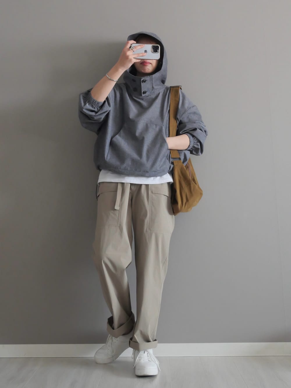 グレー系のシャツ/ブラウス、グリーン系のショルダーバッグ、ベージュ系のパンツを着用したレディースの春コーディネートの2枚目の写真