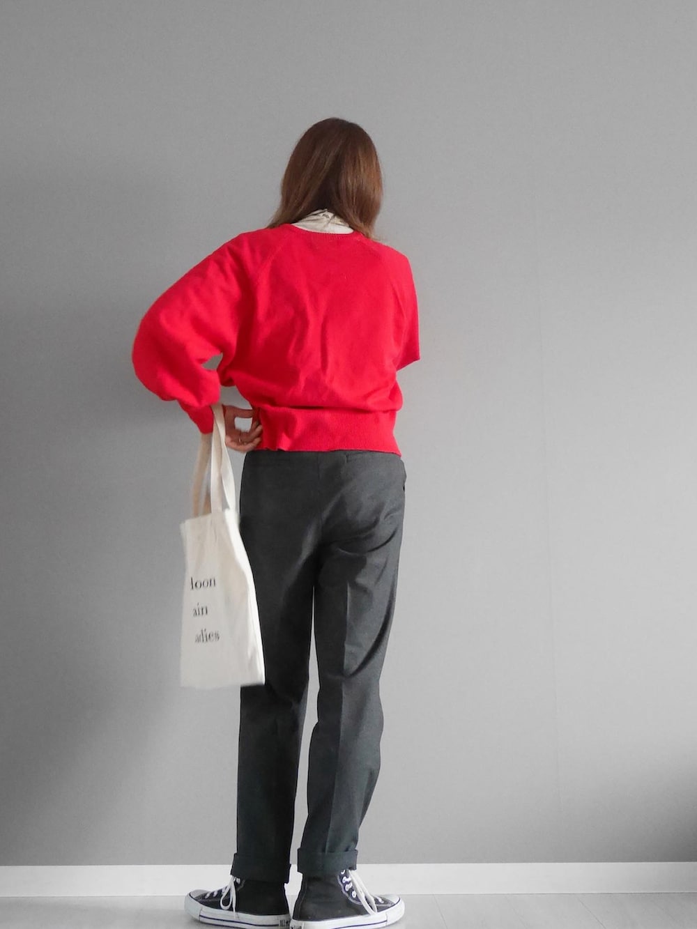 レッド系のカーディガン/ボレロ、グレー系のパンツ、ゴールド系のリングを着用したレディースの冬コーディネートの2枚目の写真