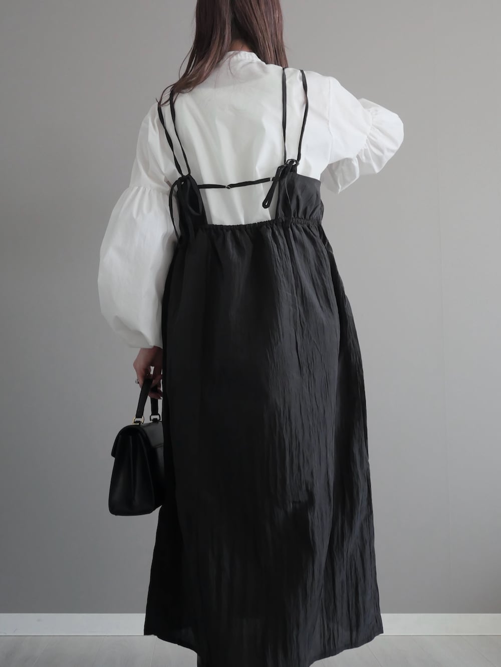 ブラック系のトートバッグ、ブラック系のブーツ、ホワイト系のシャツ/ブラウスを着用したレディースの春コーディネートの3枚目の写真