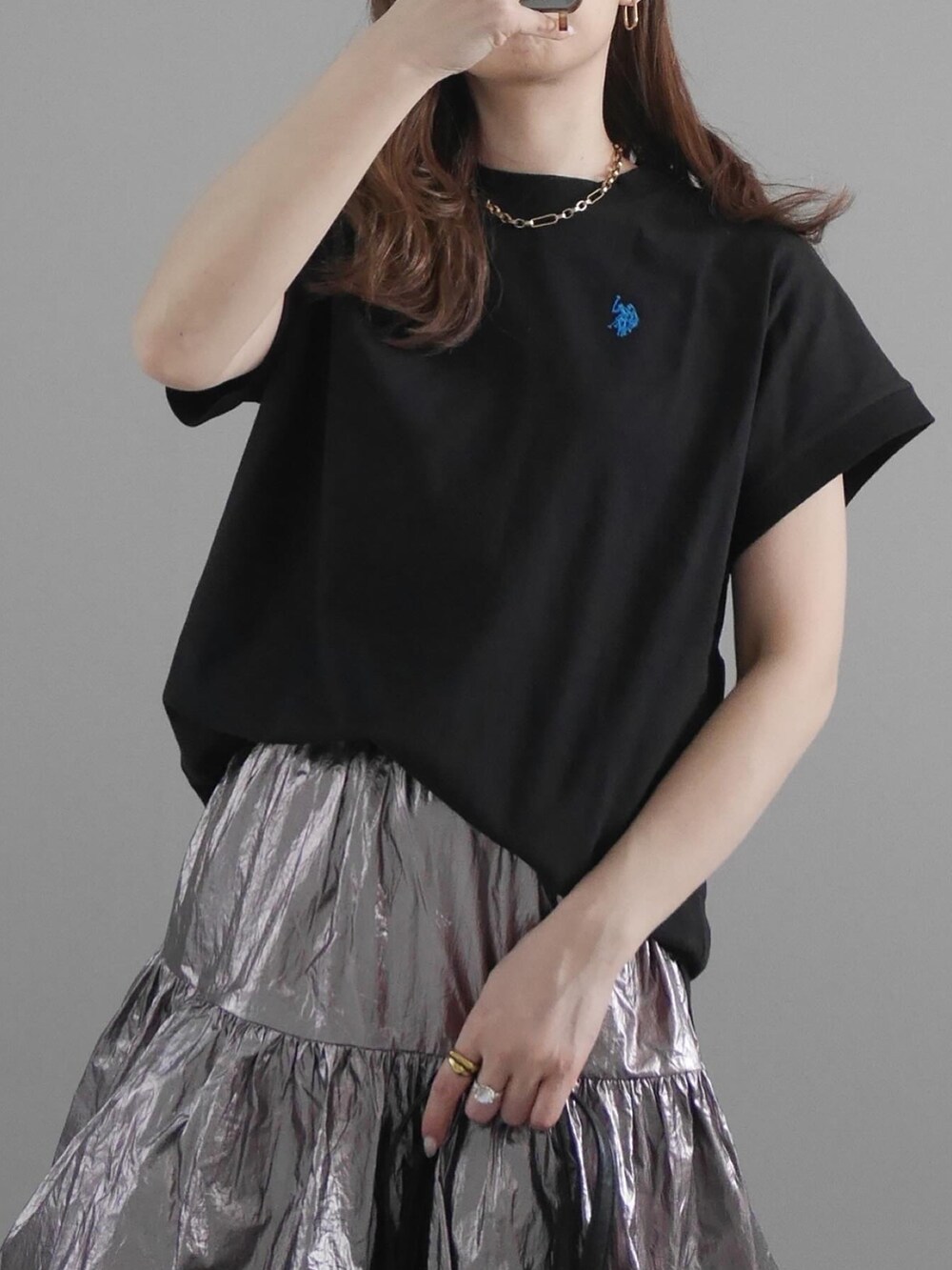 ブラック系のTシャツ/カットソー、シルバー系のスカート、ブラック系のトートバッグを着用したレディースの春コーディネートの2枚目の写真