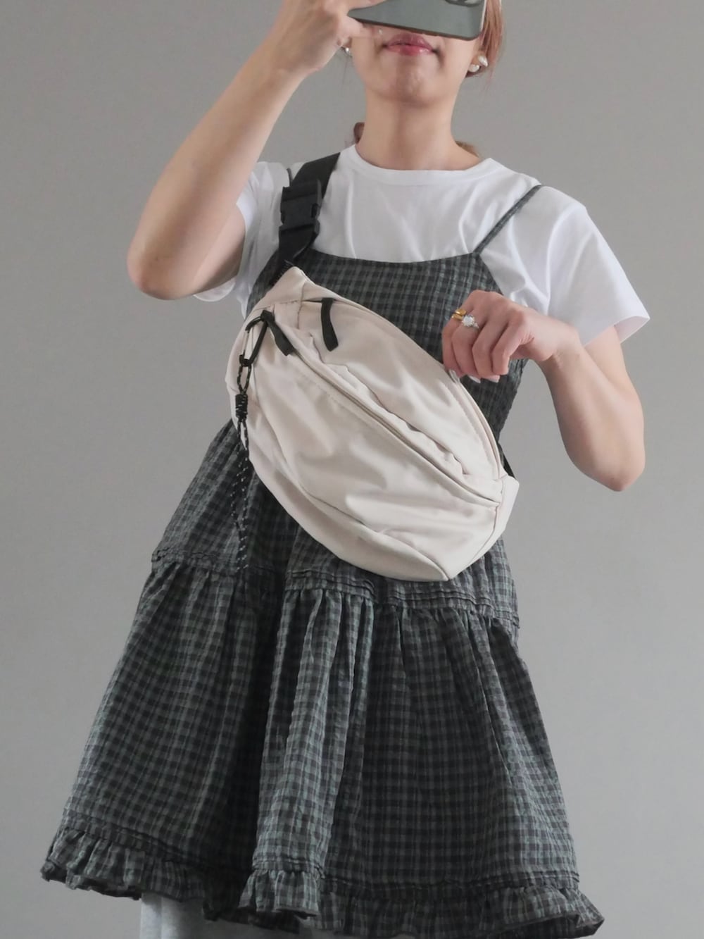 グレー系のワンピース、ホワイト系のボディバッグ/ウエストポーチ、ホワイト系のTシャツ/カットソーを着用したレディースの夏コーディネートの2枚目の写真