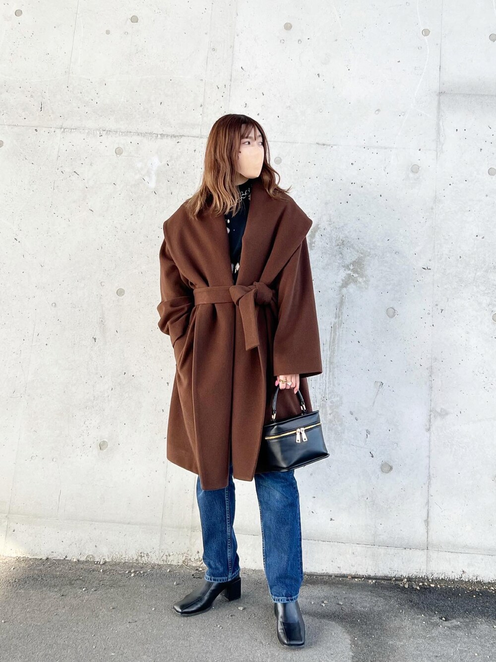 ブラウン系のその他アウター、ブラック系のニット/セーター、ブルー系のデニムパンツを着用したレディースの冬コーディネートの3枚目の写真