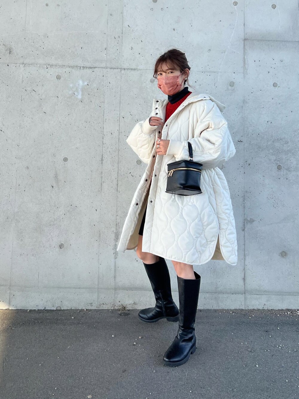 ホワイト系のダウンジャケット/コート、ブラック系のショルダーバッグ、ブラック系のブーツを着用したレディースの秋コーディネートの2枚目の写真