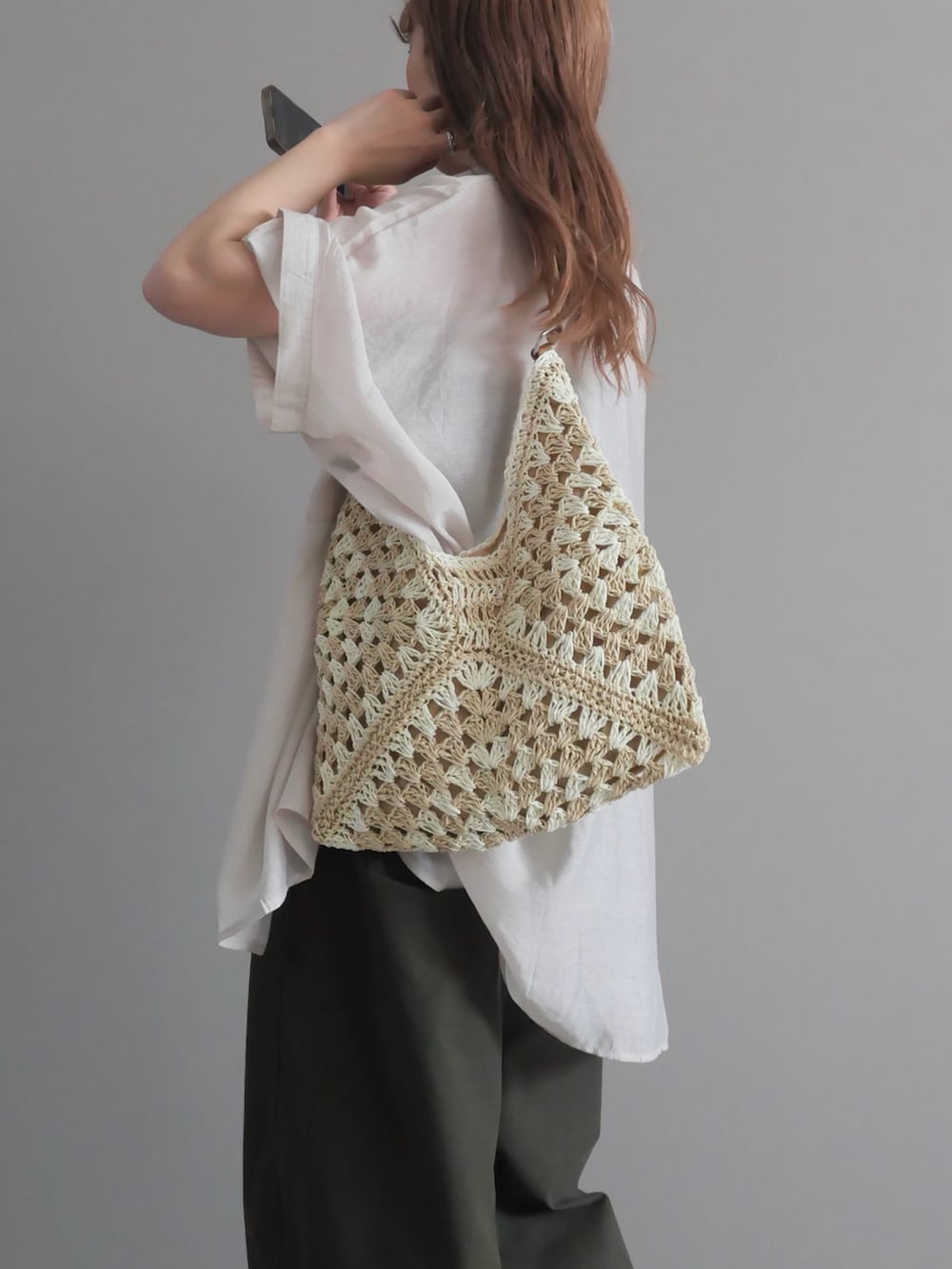 グレー系のシャツ/ブラウス、ベージュ系のかごバッグ、グリーン系のパンツを着用したレディースの春コーディネートの3枚目の写真