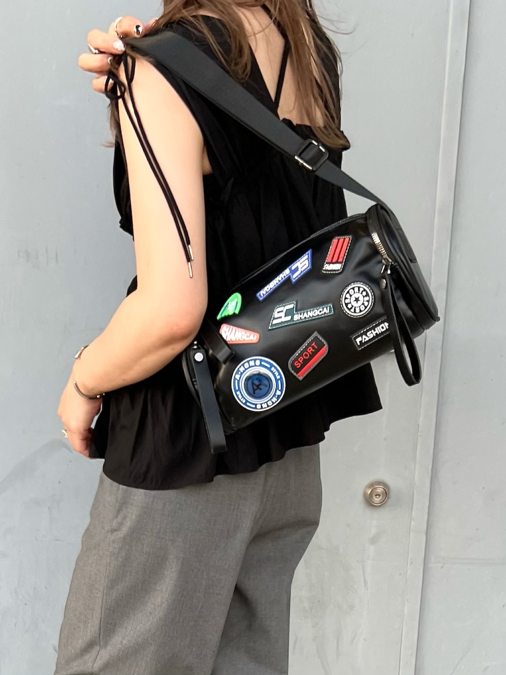 ブラック系のシャツ/ブラウス、ブラック系のショルダーバッグ、シルバー系のサンダルを着用したレディースの秋コーディネートの2枚目の写真