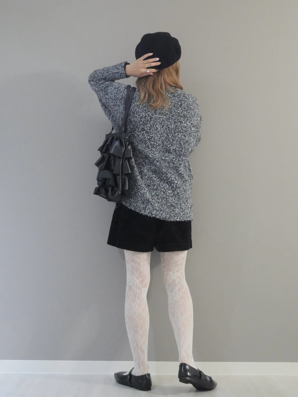 グレー系のカーディガン/ボレロ、ブラック系のトートバッグ、ホワイト系のタイツ/ストッキングを着用したレディースの秋コーディネートの3枚目の写真