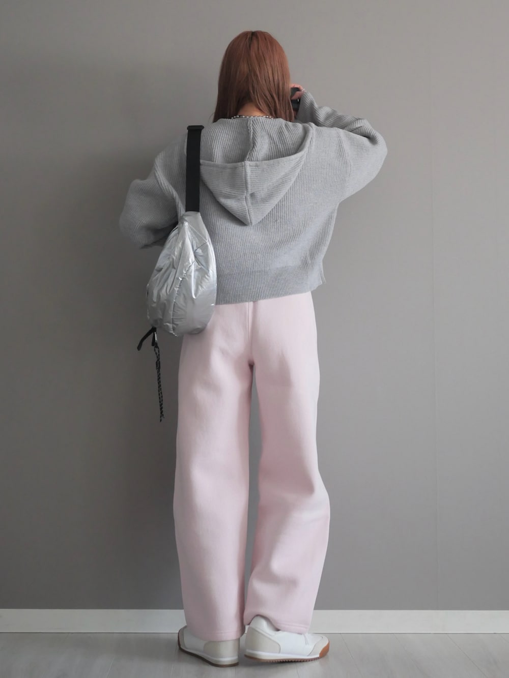 グレー系のパーカー、シルバー系のボディバッグ/ウエストポーチを着用したレディースの冬コーディネートの5枚目の写真