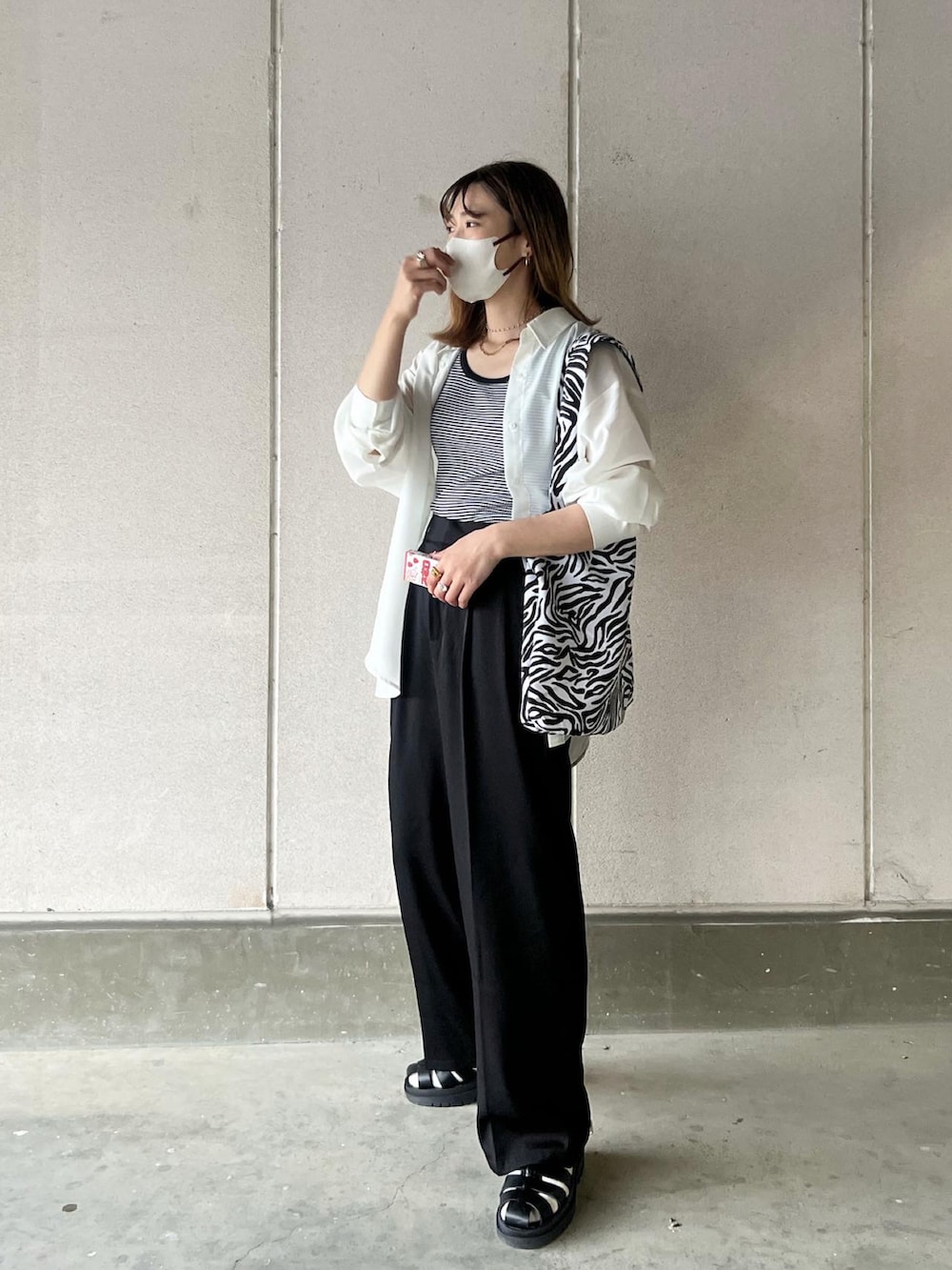 ブラック系のスラックス、その他のトートバッグ、ブラック系のサンダルを着用したレディースの春コーディネートの2枚目の写真