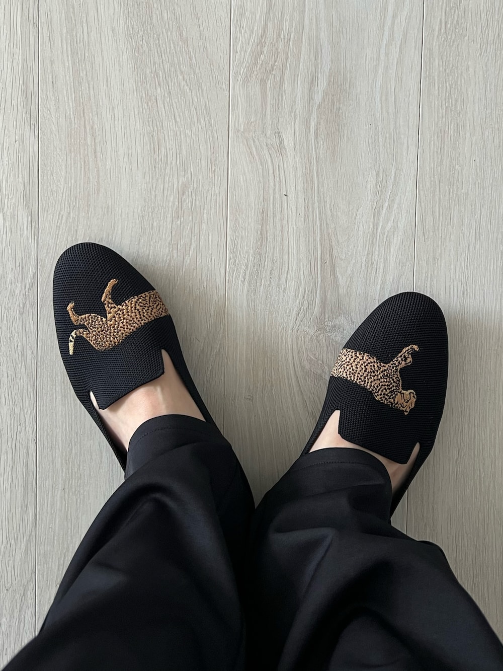 ホワイト系のカーディガン/ボレロ、ブラック系のタンクトップ、ブラック系のスラックスを着用したレディースの秋コーディネートの4枚目の写真