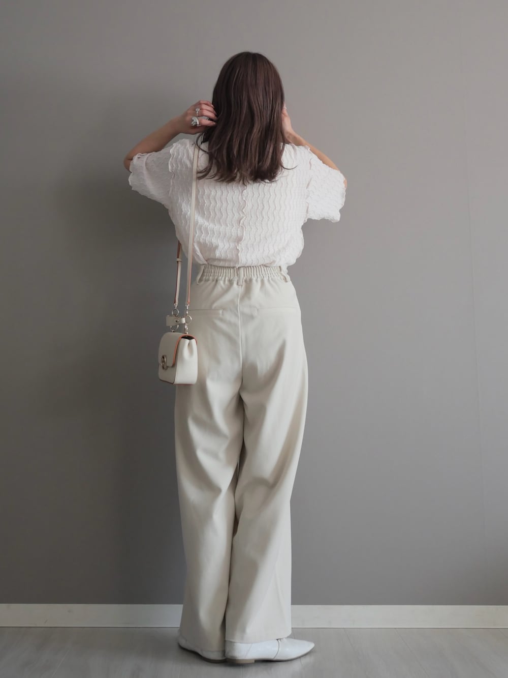 ホワイト系のスラックス、ホワイト系のパンプス、ホワイト系のTシャツ/カットソーを着用したレディースの春コーディネートの4枚目の写真