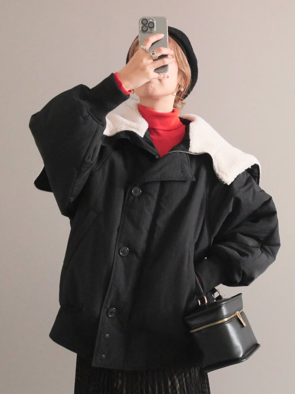 ブラック系のブルゾン、グレー系のスカート、ブラック系のショルダーバッグを着用したレディースの秋コーディネートの2枚目の写真