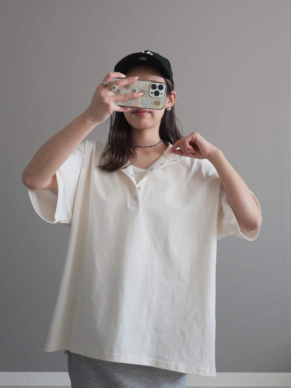 ブラック系のショルダーバッグ、ブラック系のスニーカー、シルバー系のネックレスを着用したレディースの春コーディネートの2枚目の写真