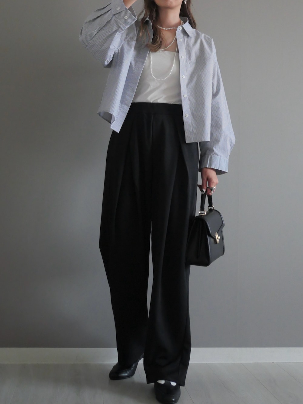 ブラック系のトートバッグ、ブラック系のスラックス、ブラック系のパンプスを着用したレディースの秋コーディネートの2枚目の写真