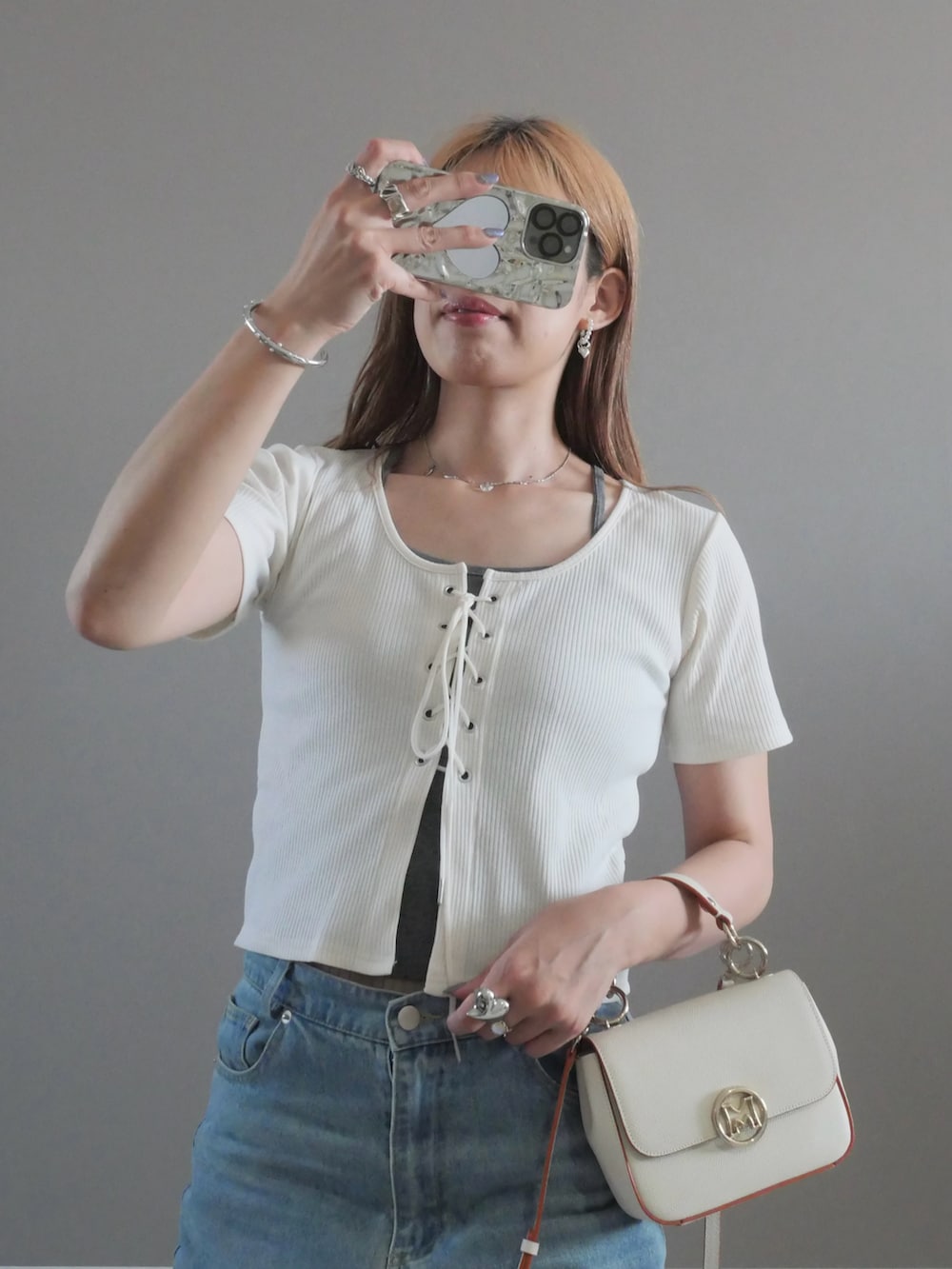 ホワイト系のハンドバッグ、ホワイト系のサンダル、ホワイト系のTシャツ/カットソーを着用したレディースの夏コーディネートの2枚目の写真