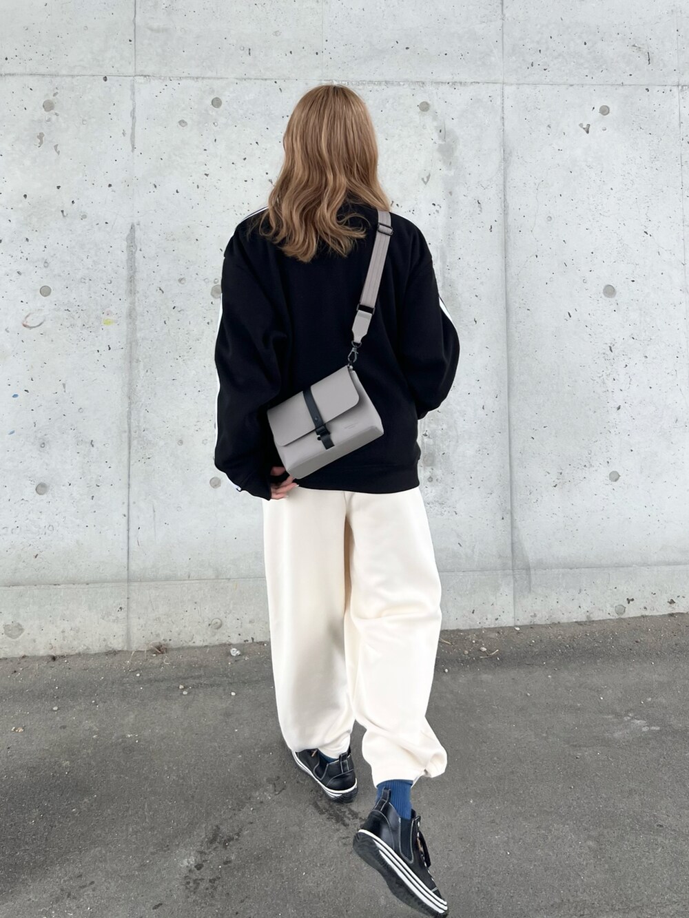 ブラック系のスウェット、ホワイト系のTシャツ/カットソー、ホワイト系のスウェットパンツを着用したレディースの秋コーディネートの4枚目の写真