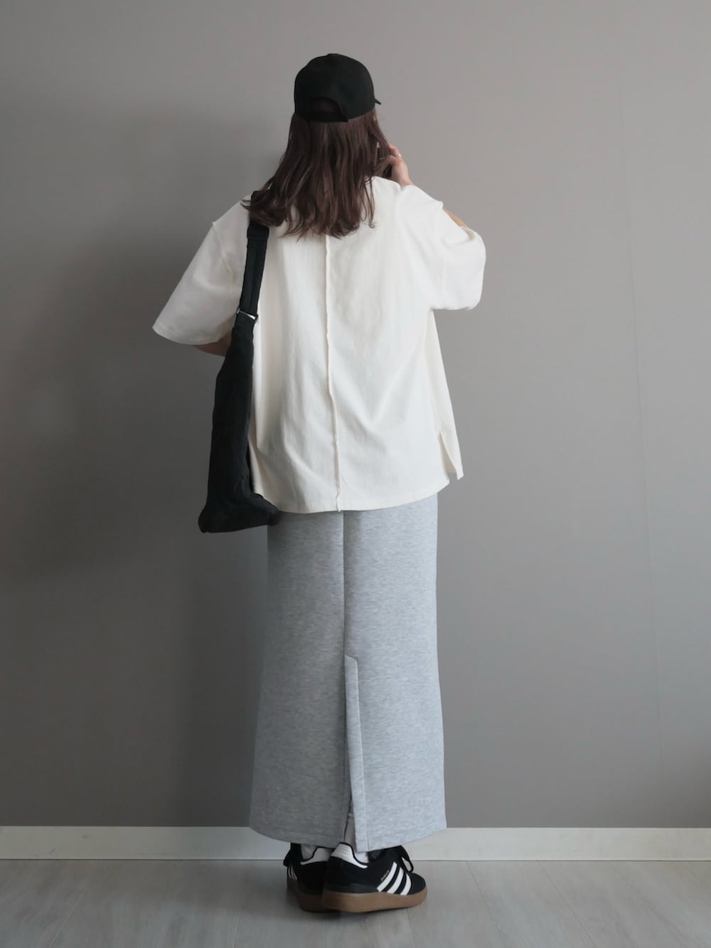 ブラック系のショルダーバッグ、ブラック系のスニーカー、シルバー系のネックレスを着用したレディースの春コーディネートの4枚目の写真