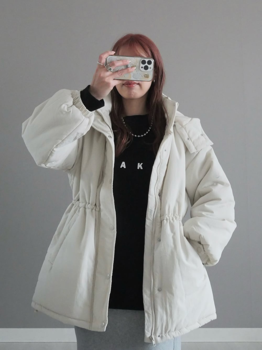 ホワイト系のダウンジャケット/コート、ブラック系のブーツ、ブラック系のTシャツ/カットソーを着用したレディースの冬コーディネートの2枚目の写真