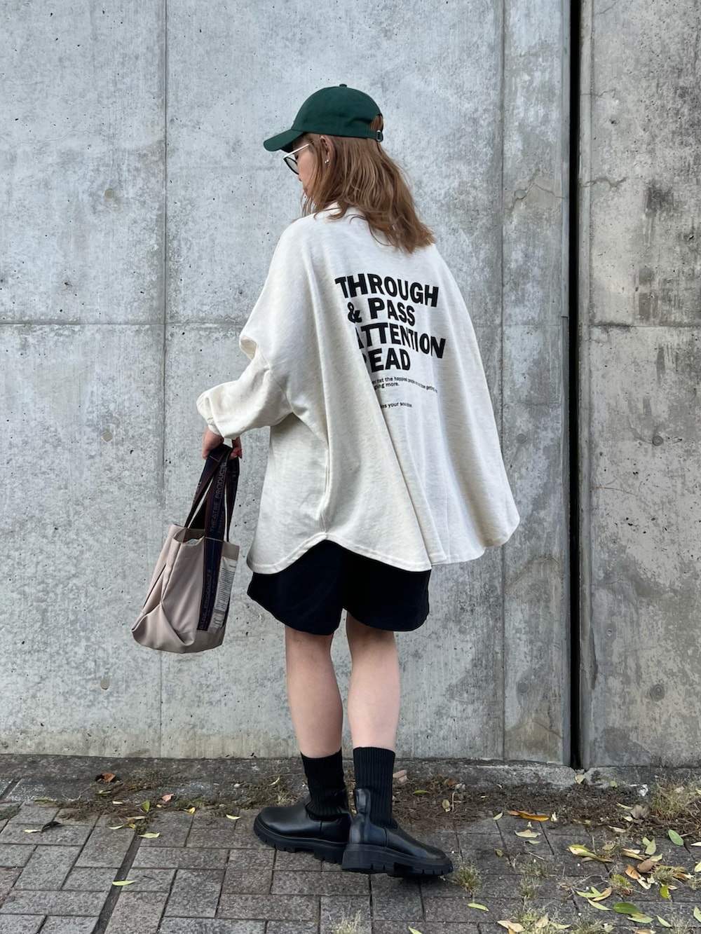 ベージュ系のスウェット、ブルー系のパンツ、ベージュ系のトートバッグを着用したレディースの秋コーディネートの3枚目の写真