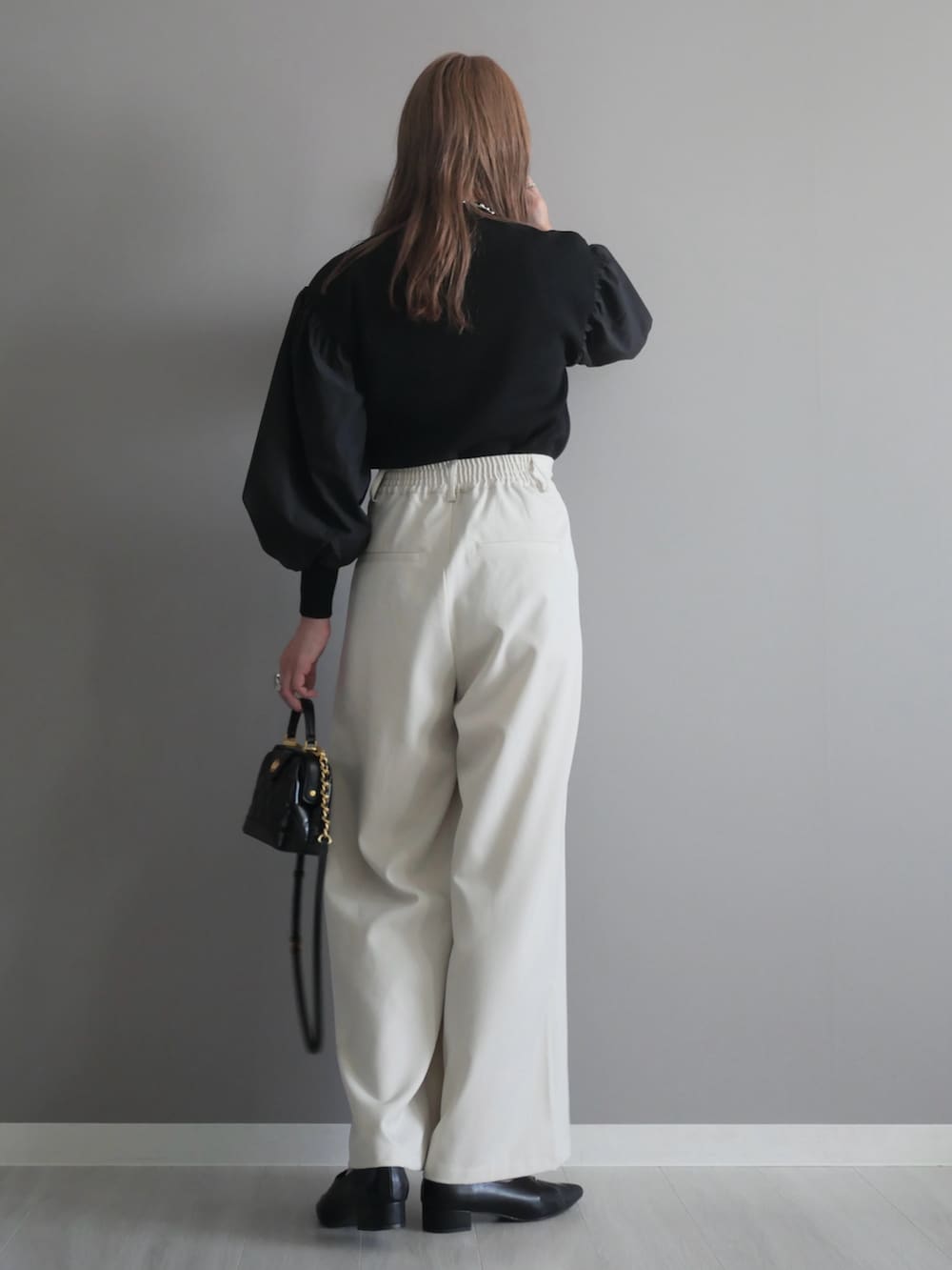 ブラック系のトートバッグ、ブラック系のニット/セーター、ブラック系のパンプスを着用したレディースの秋コーディネートの5枚目の写真