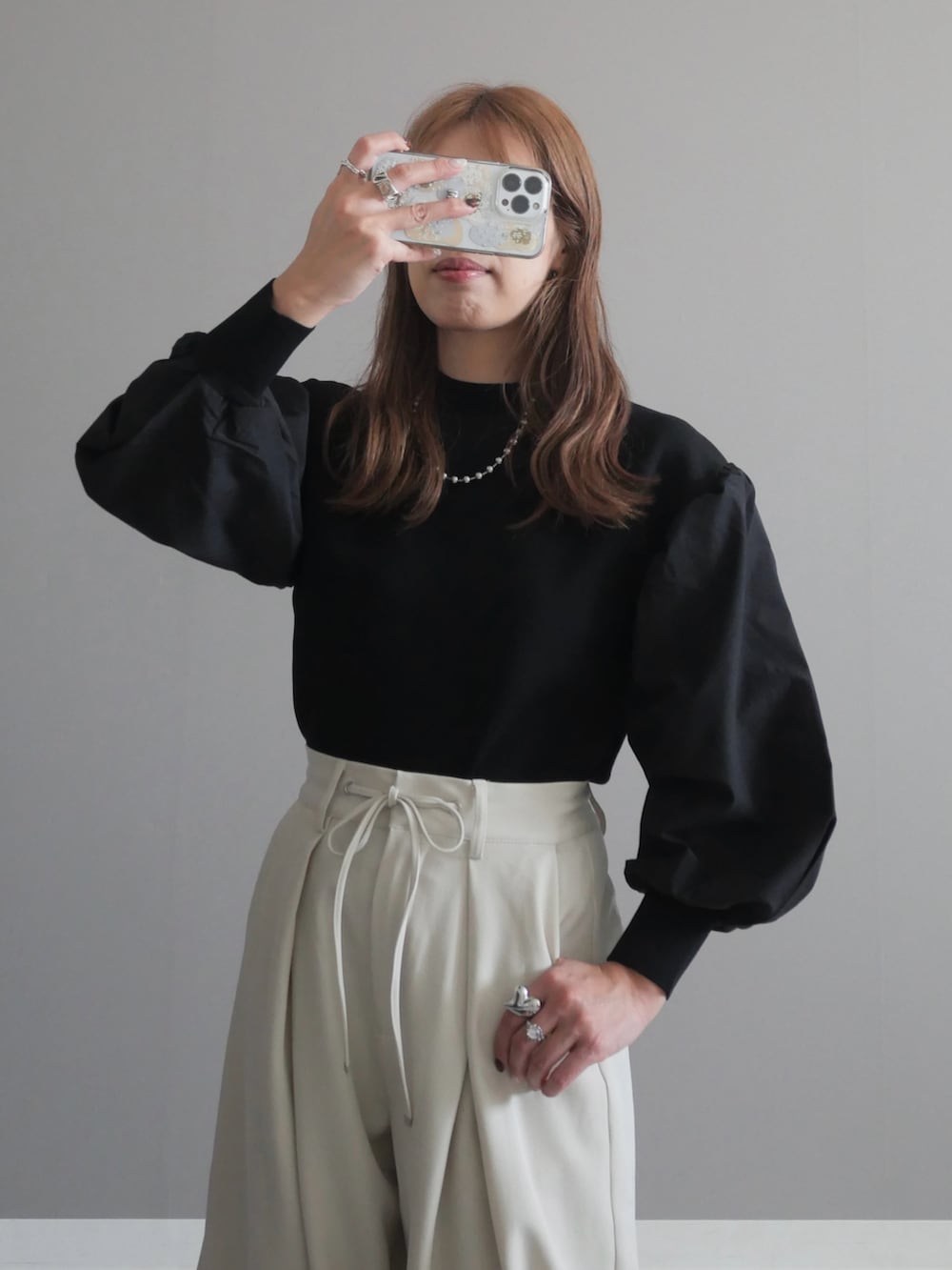 ブラック系のトートバッグ、ブラック系のニット/セーター、ブラック系のパンプスを着用したレディースの秋コーディネートの2枚目の写真