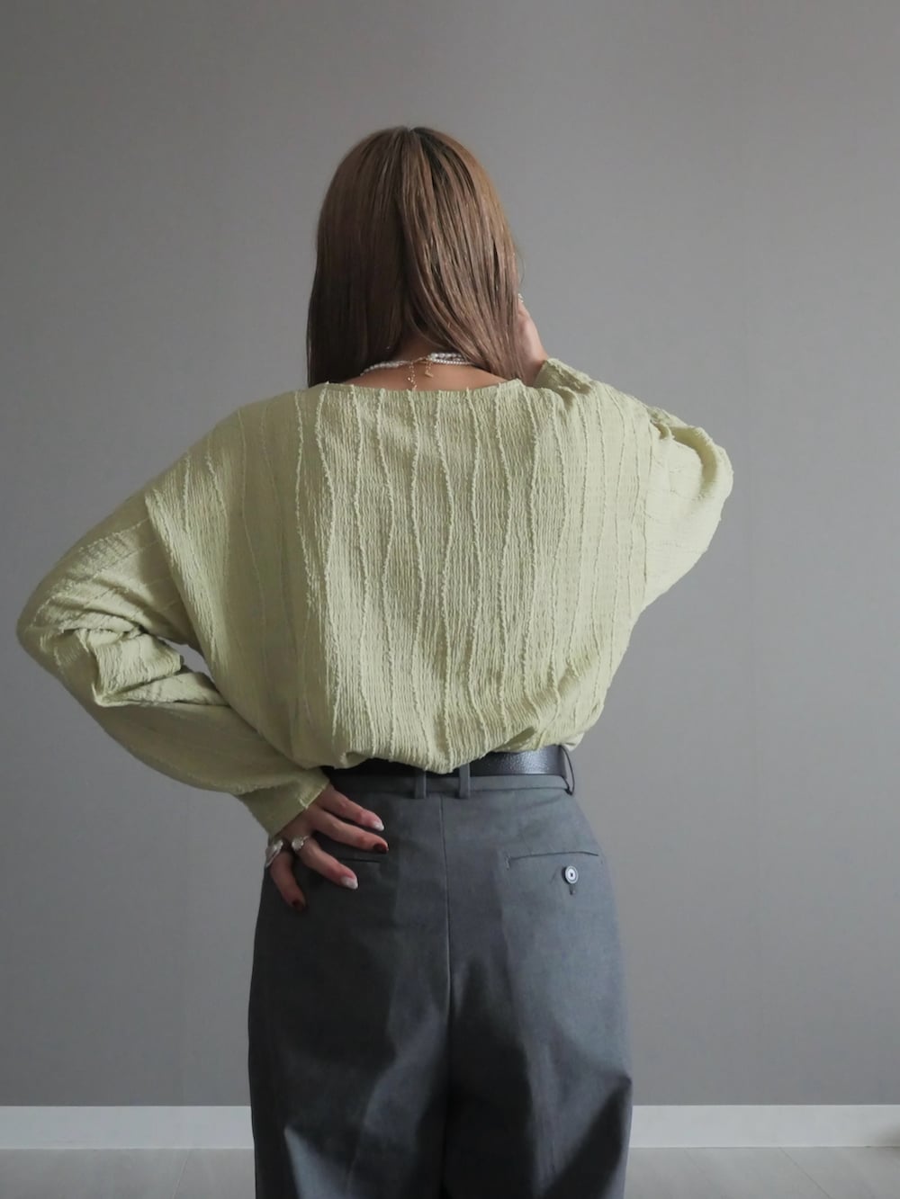 ブラック系のトートバッグ、グリーン系のTシャツ/カットソー、ブラック系のパンプスを着用したレディースの秋コーディネートの3枚目の写真