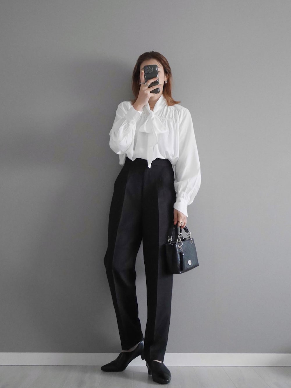 ホワイト系のシャツ/ブラウス、ブラック系のセットアップ、ブラック系のショルダーバッグを着用したレディースの春コーディネートの2枚目の写真