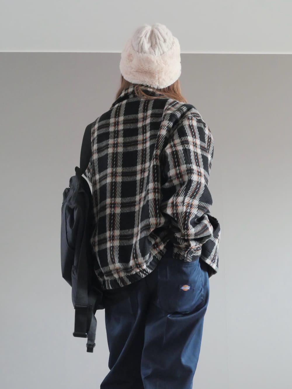 ブルー系のチノパンツ、ブラック系のブルゾン、ブラック系のTシャツ/カットソーを着用したレディースの冬コーディネートの3枚目の写真