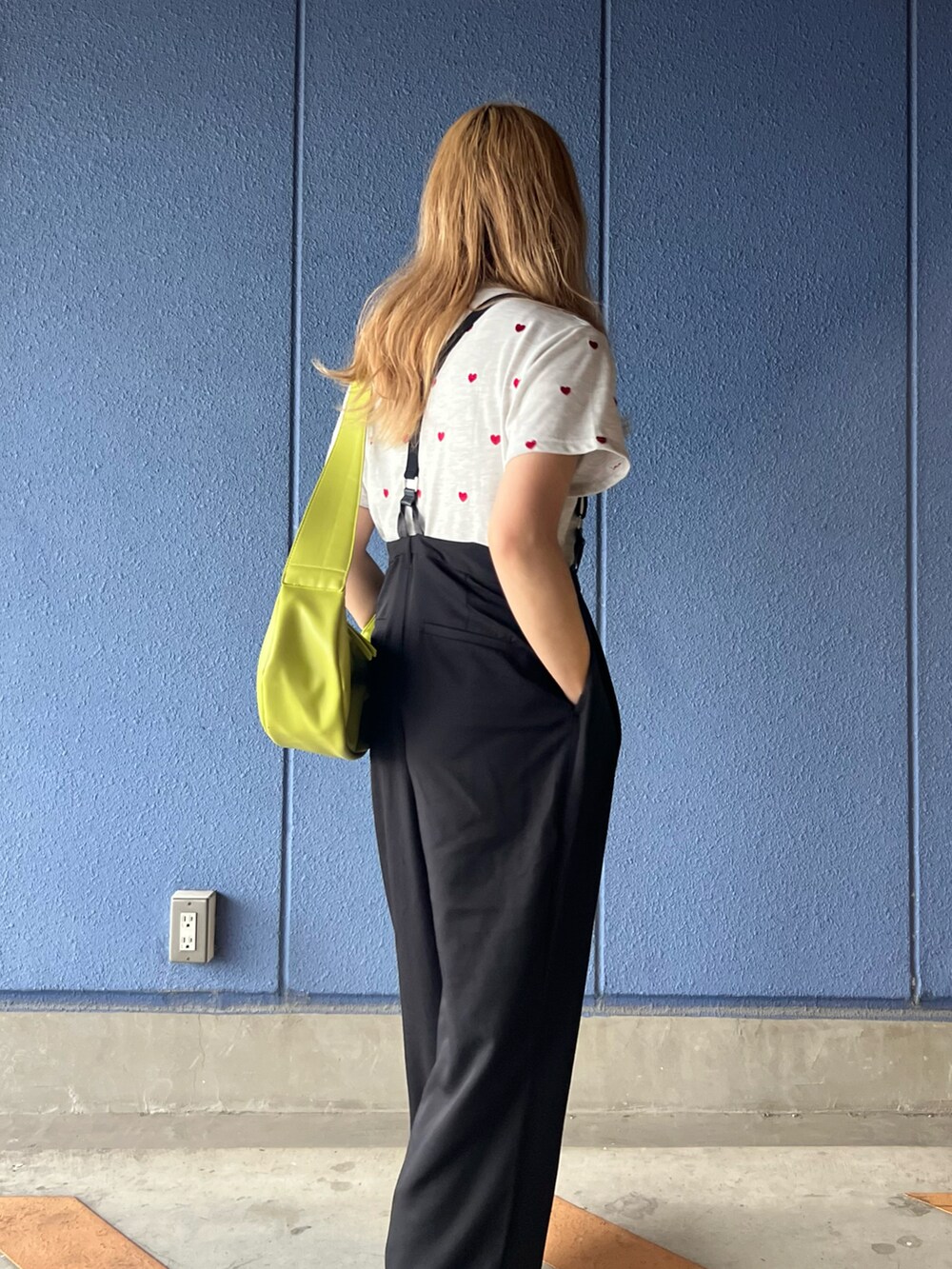 ブラック系のサロペット/オーバーオール、ベージュ系のTシャツ/カットソー、グリーン系のショルダーバッグを着用したレディースの夏コーディネートの3枚目の写真