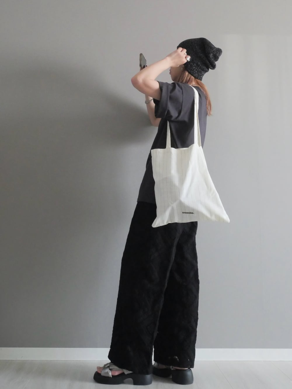 ブラック系のスラックス、グレー系のTシャツ/カットソー、ホワイト系のトートバッグを着用したレディースの夏コーディネートの3枚目の写真