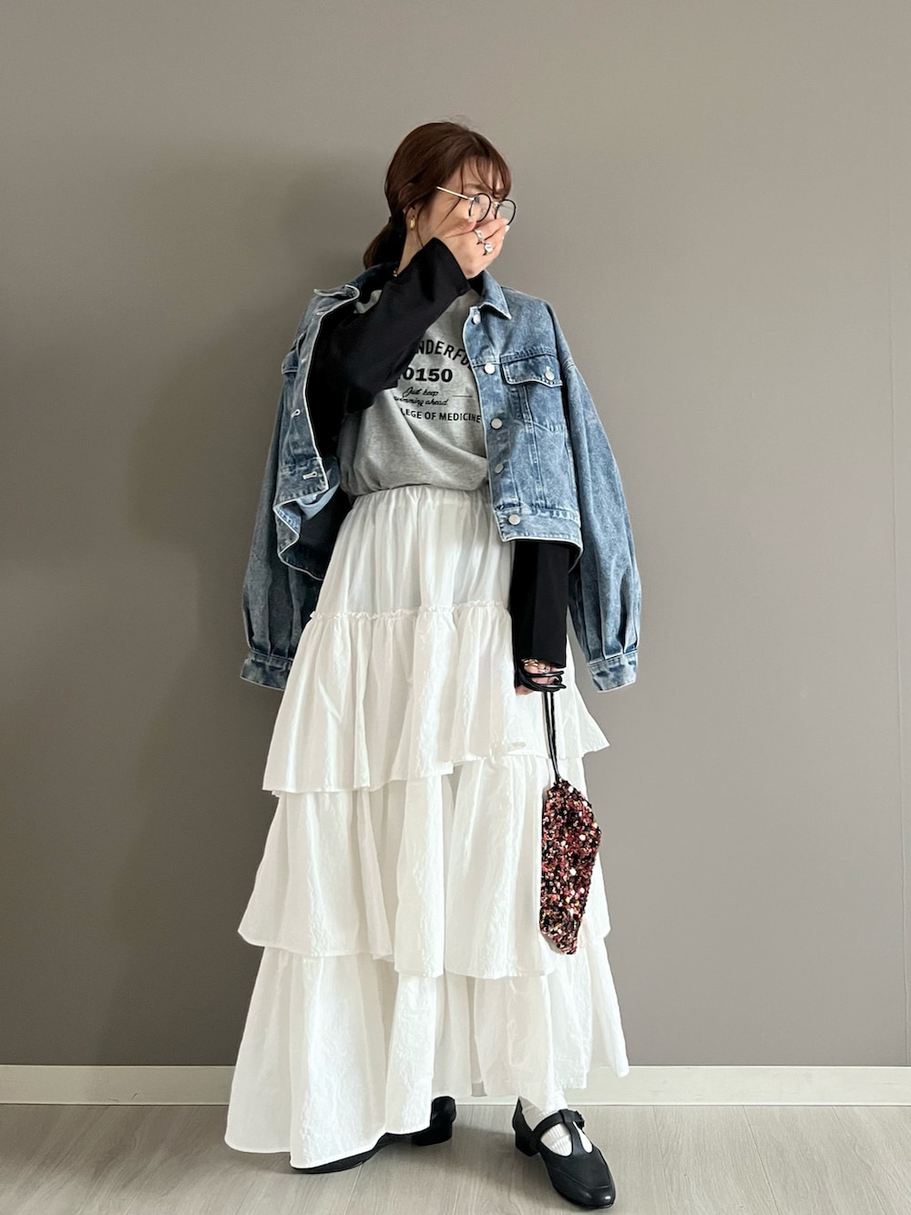 ブルー系のデニムジャケット、グレー系のTシャツ/カットソー、ホワイト系のスカートを着用したレディースの春コーディネートの2枚目の写真