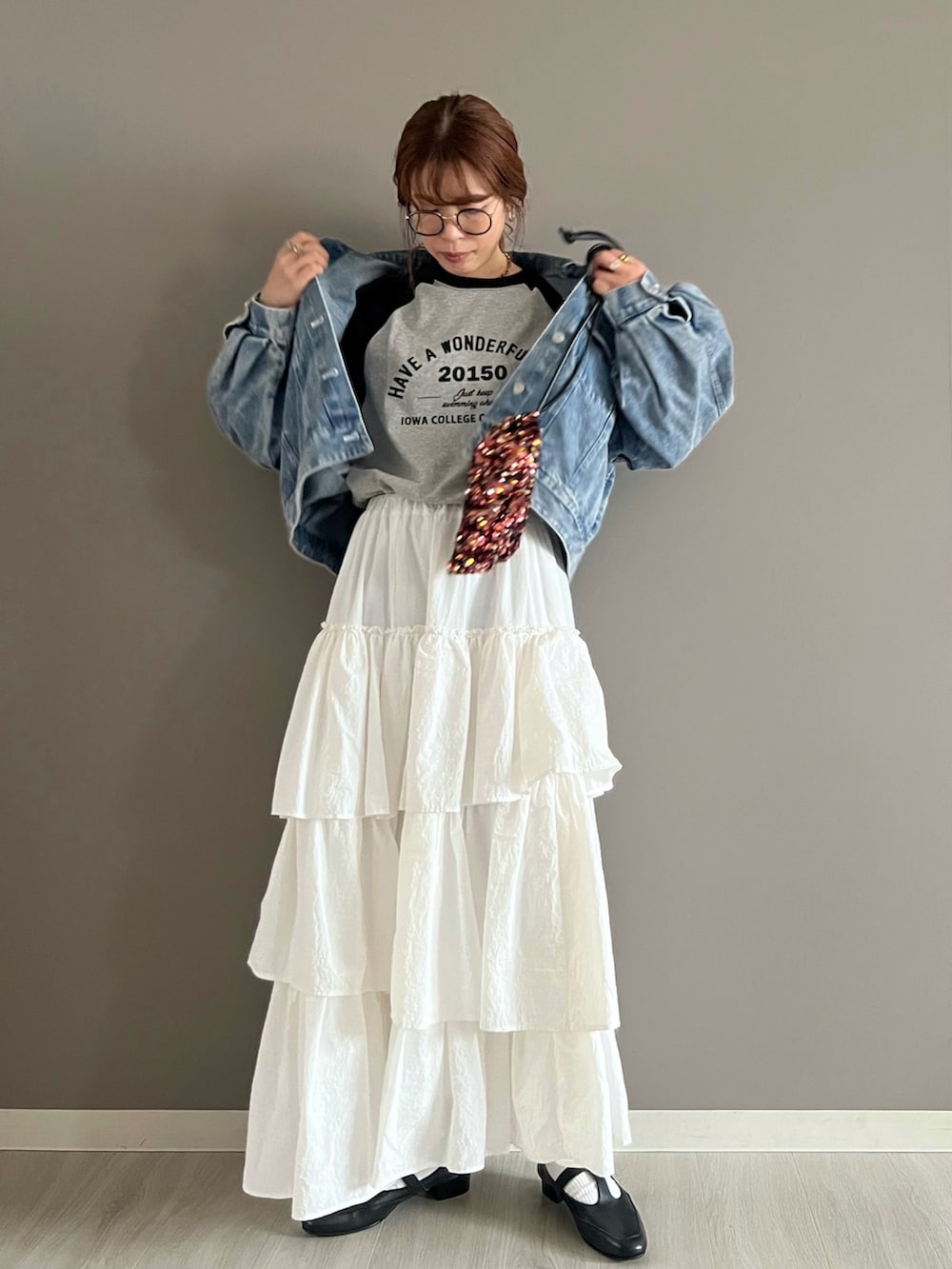 ブルー系のデニムジャケット、グレー系のTシャツ/カットソー、ホワイト系のスカートを着用したレディースの春コーディネートの3枚目の写真