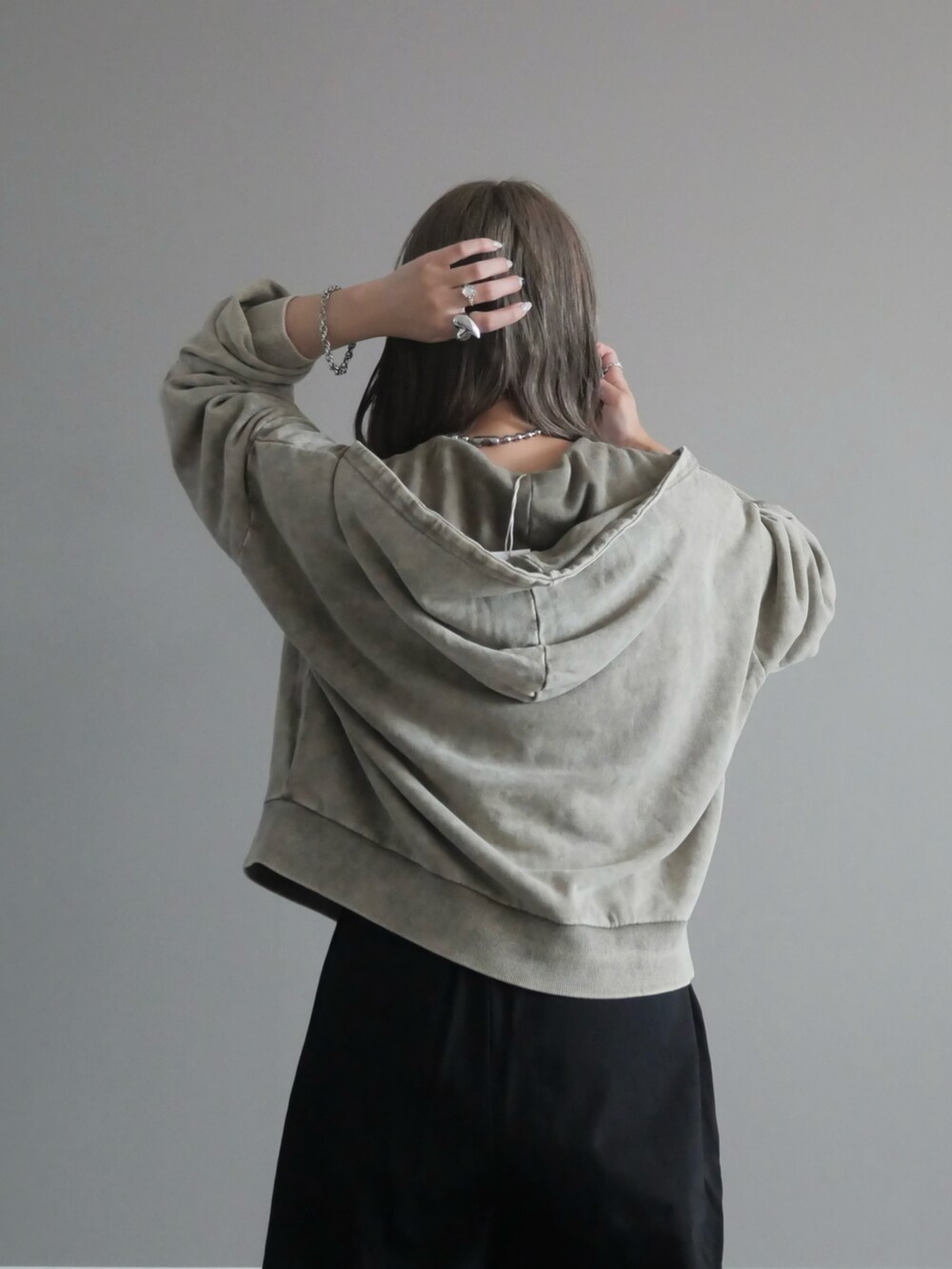 グレー系のパーカー、ホワイト系のトートバッグ、ブラック系のチノパンツを着用したレディースの秋コーディネートの3枚目の写真