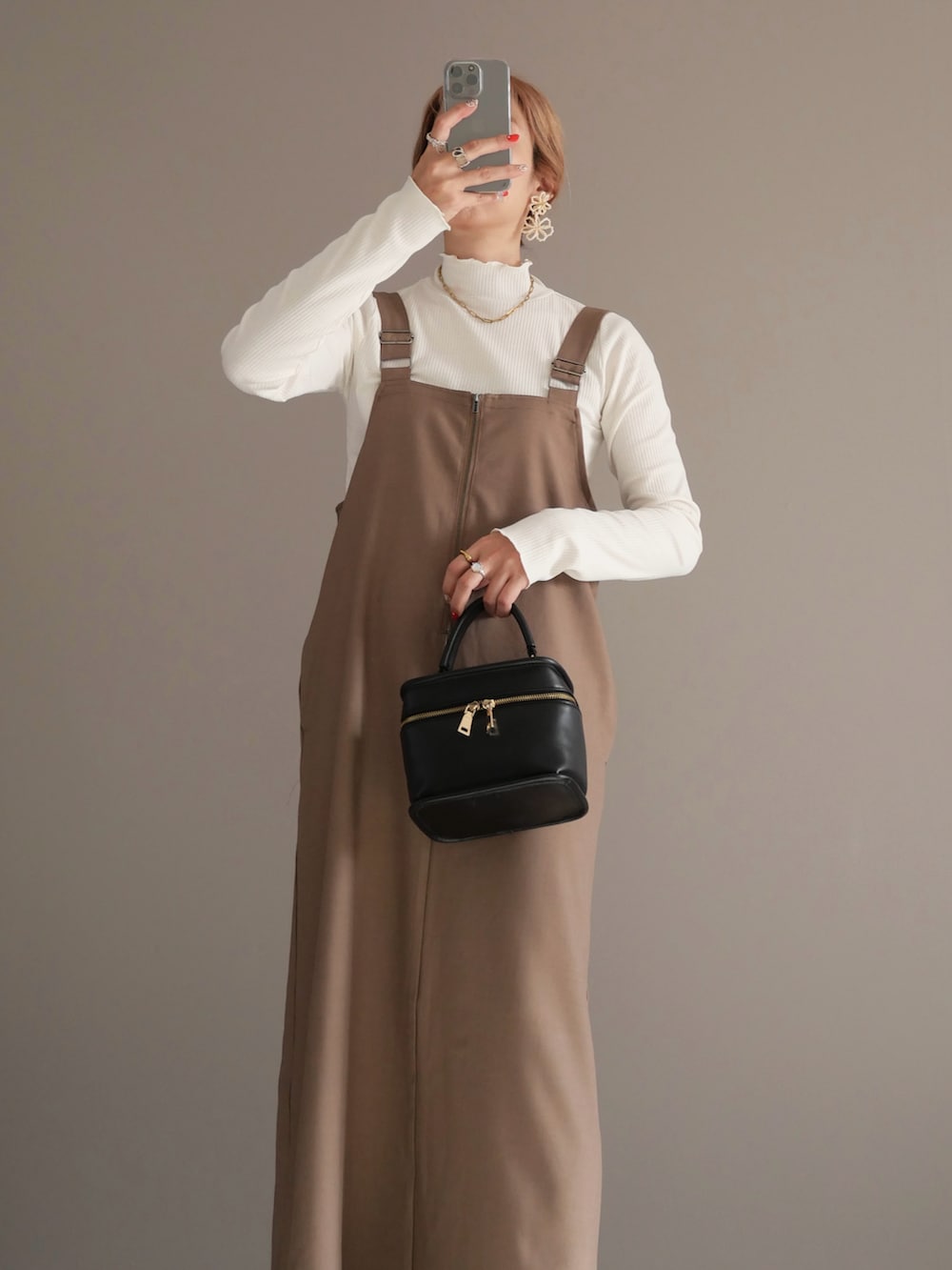 ブラウン系のブルゾン、ホワイト系のTシャツ/カットソー、ベージュ系のワンピースを着用したレディースの秋コーディネートの3枚目の写真