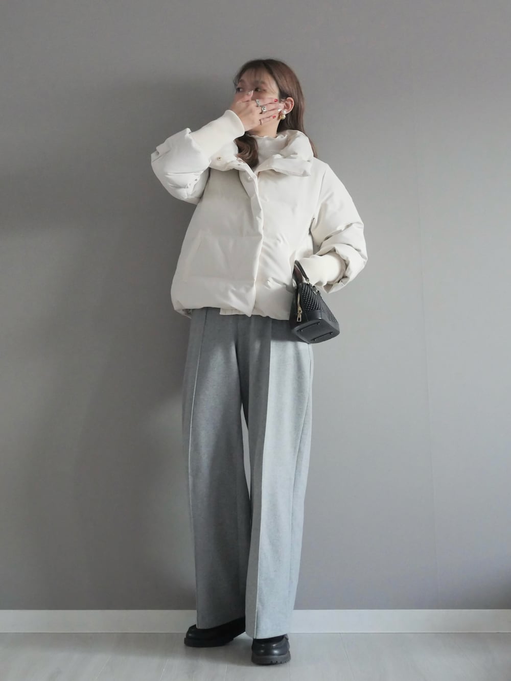 ホワイト系のダウンジャケット/コート、ホワイト系のTシャツ/カットソー、ブラック系のベストを着用したレディースの冬コーディネートの4枚目の写真