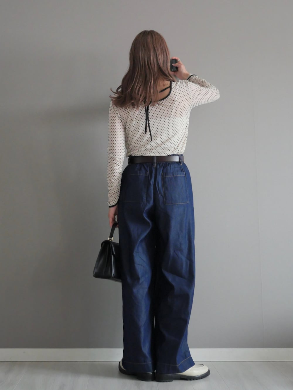 ホワイト系のTシャツ/カットソー、ホワイト系のローファー、ブルー系のデニムパンツを着用したレディースの春コーディネートの4枚目の写真