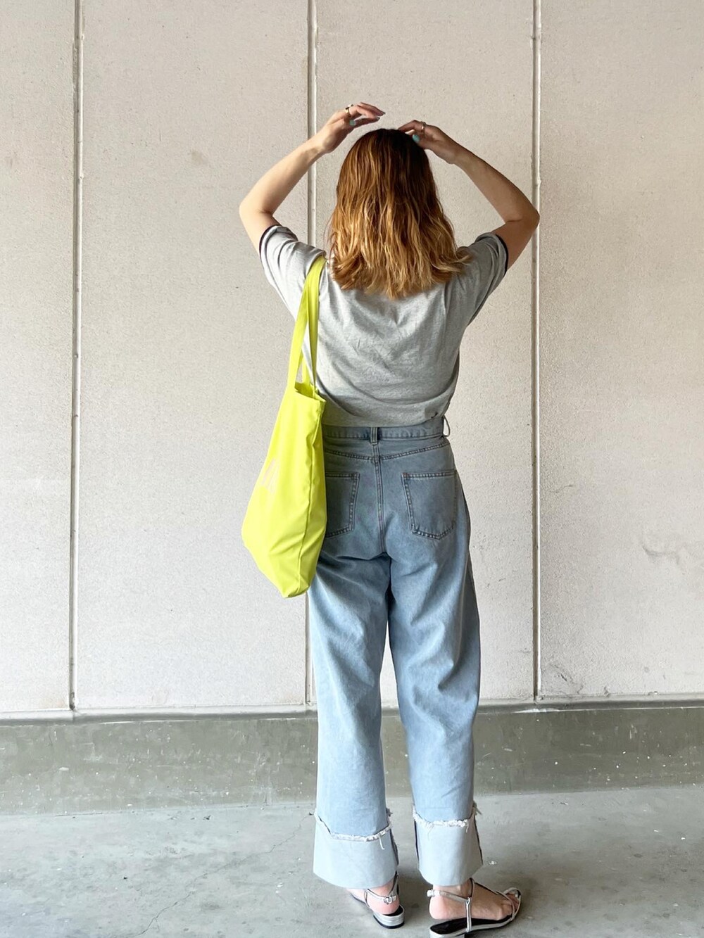 グレー系のTシャツ/カットソー、ブルー系のデニムパンツ、イエロー系のトートバッグを着用したレディースの春コーディネートの2枚目の写真