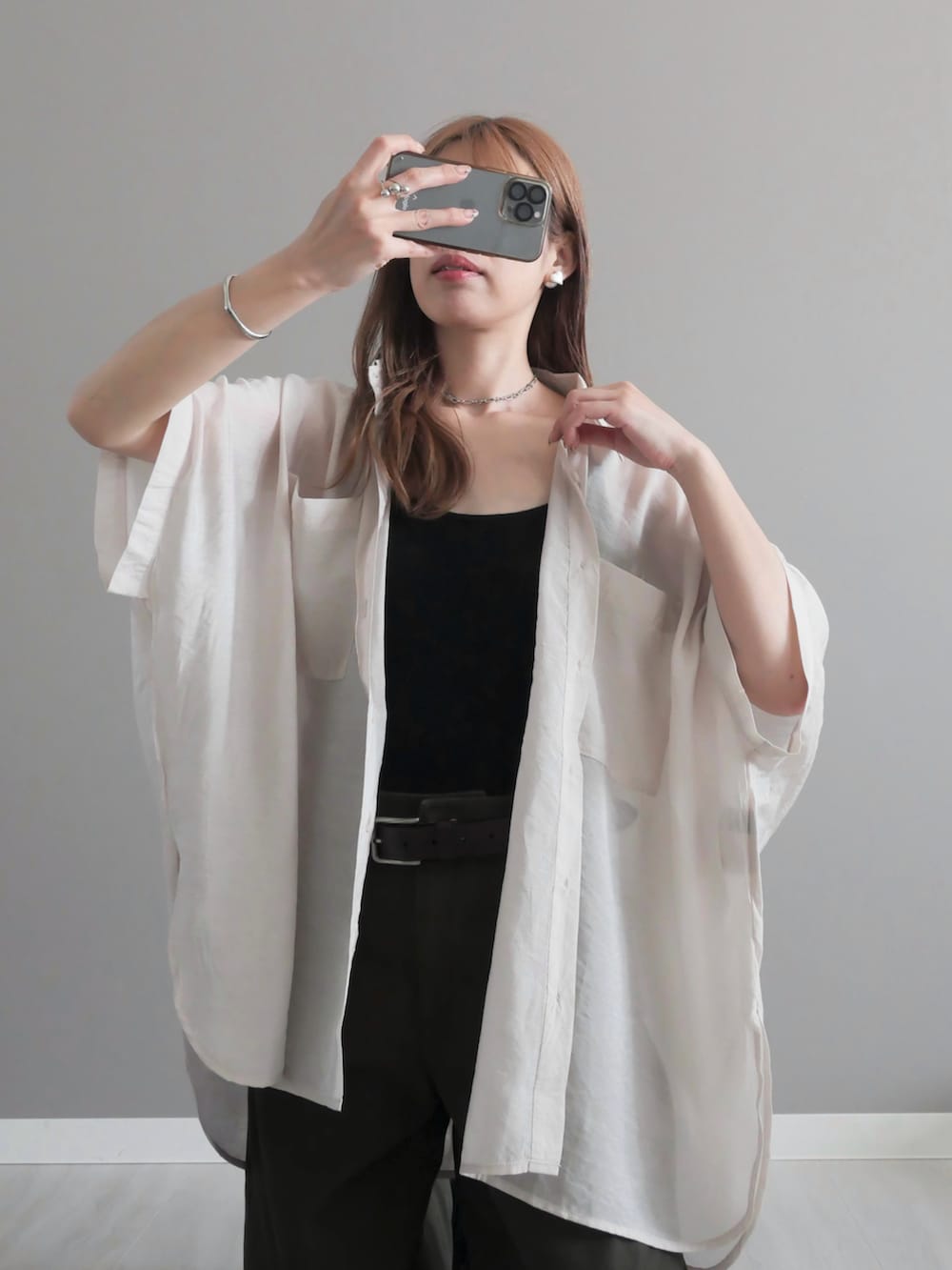 グレー系のシャツ/ブラウス、ベージュ系のかごバッグ、グリーン系のパンツを着用したレディースの春コーディネートの2枚目の写真