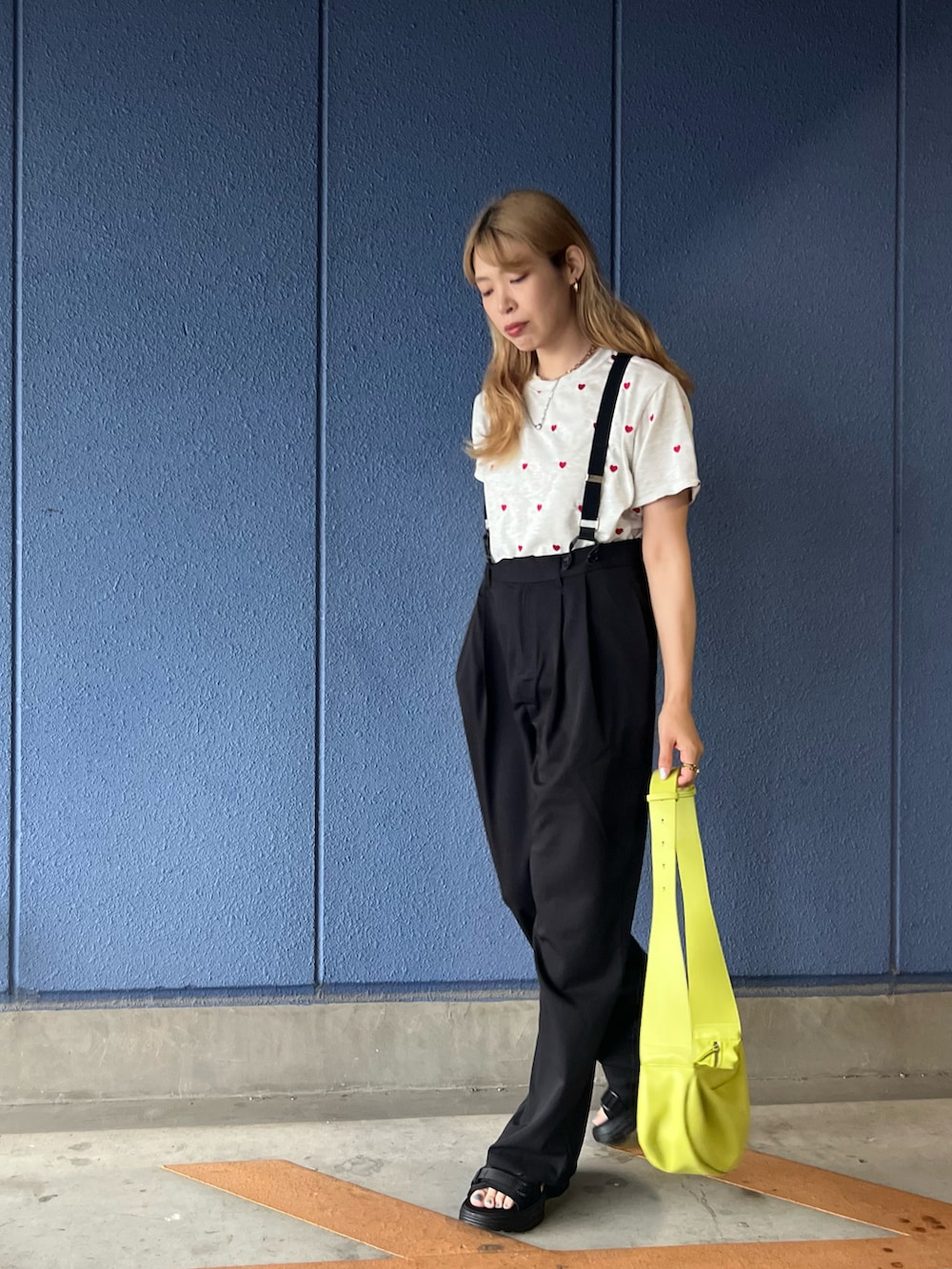 ブラック系のサロペット/オーバーオール、ベージュ系のTシャツ/カットソー、グリーン系のショルダーバッグを着用したレディースの夏コーディネートの2枚目の写真