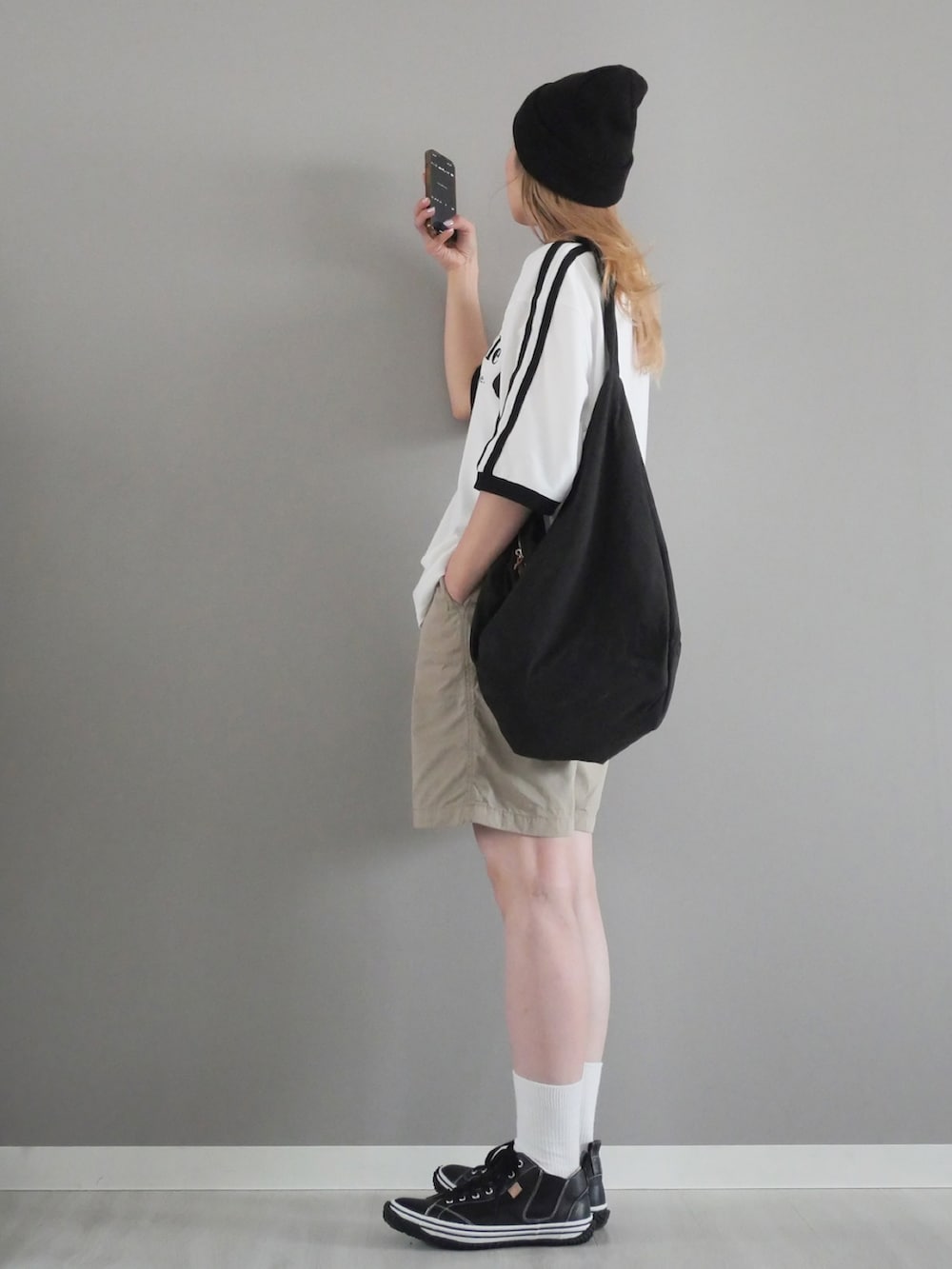 ブラック系のスニーカー、ホワイト系のTシャツ/カットソー、ベージュ系のパンツを着用したレディースの春コーディネートの3枚目の写真