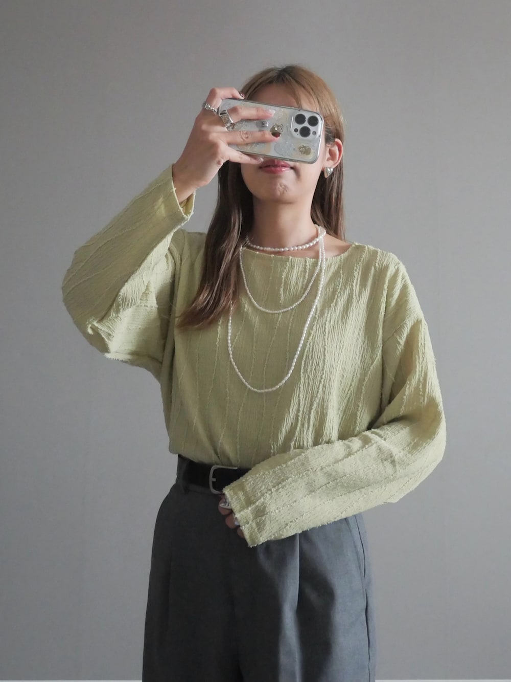 ブラック系のトートバッグ、グリーン系のTシャツ/カットソー、ブラック系のパンプスを着用したレディースの秋コーディネートの2枚目の写真