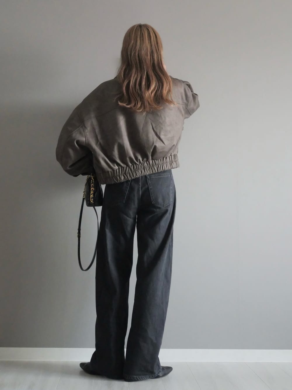 ブラウン系のブルゾン、ブラック系のトートバッグ、ブラック系のパンプスを着用したレディースの秋コーディネートの5枚目の写真