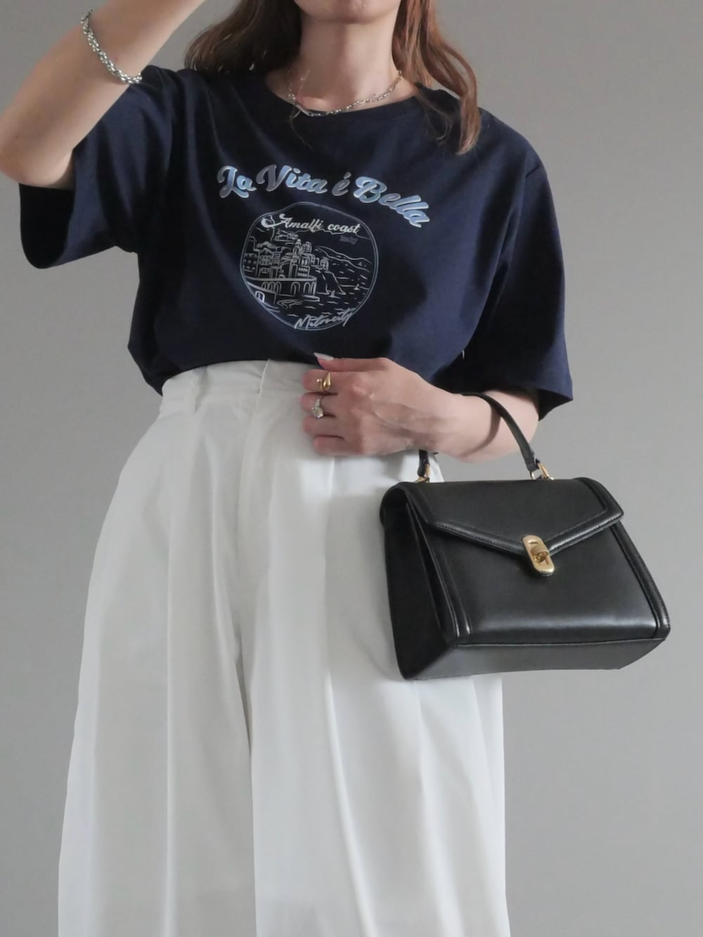 ブルー系のTシャツ/カットソー、ブラック系のトートバッグ、ホワイト系のチノパンツを着用したレディースの夏コーディネートの3枚目の写真