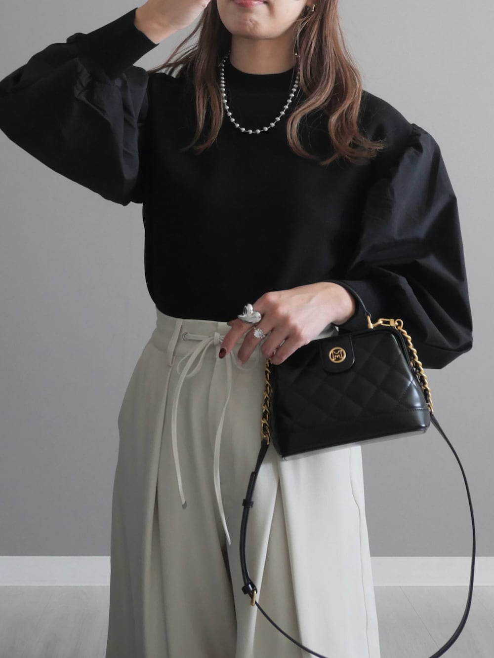 ブラック系のトートバッグ、ブラック系のニット/セーター、ブラック系のパンプスを着用したレディースの秋コーディネートの3枚目の写真