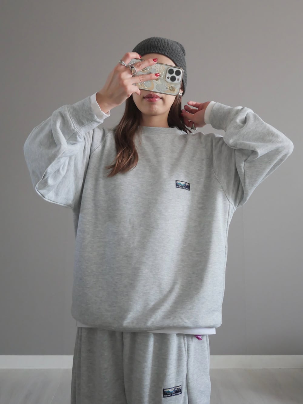 グレー系のスウェット、グレー系のスウェットパンツ、ブラウン系のメッセンジャーバッグを着用したレディースの冬コーディネートの4枚目の写真