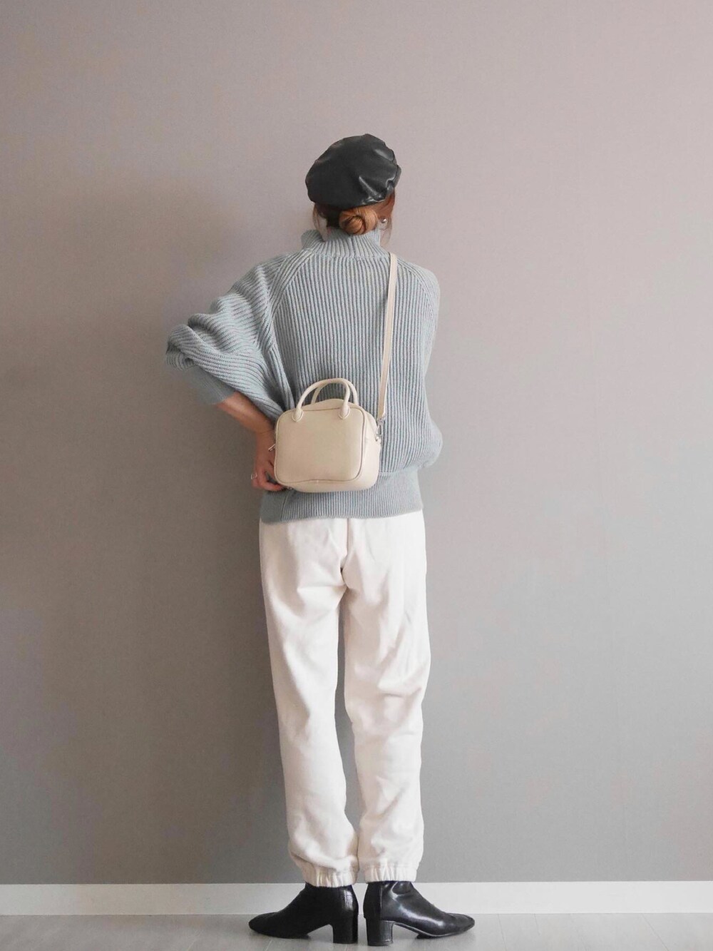 ブルー系のニット/セーター、ホワイト系のボストンバッグ、ホワイト系のパンツを着用したレディースの秋コーディネートの3枚目の写真