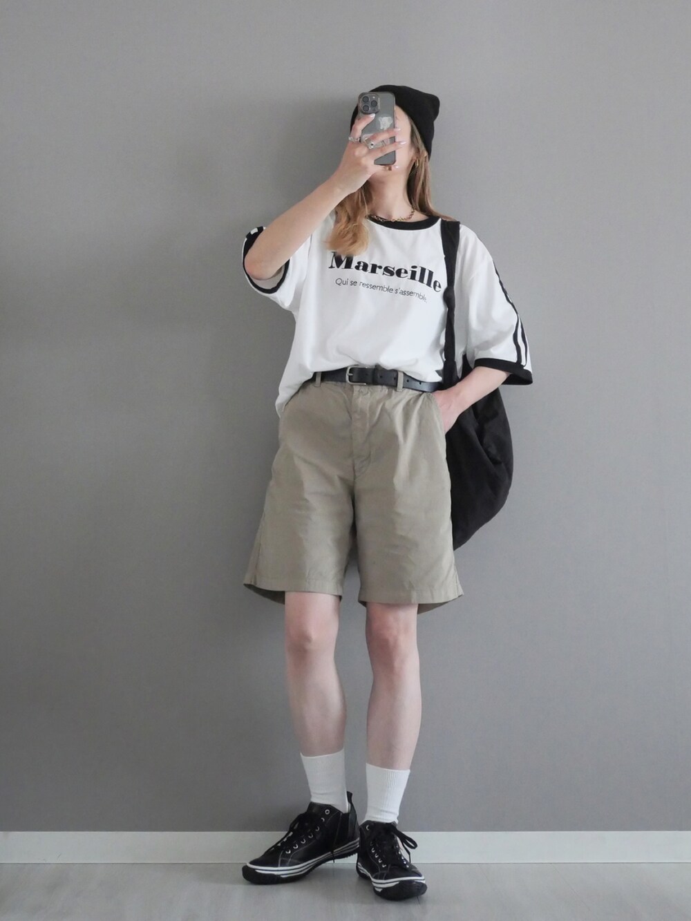 ブラック系のスニーカー、ホワイト系のTシャツ/カットソー、ベージュ系のパンツを着用したレディースの春コーディネートの2枚目の写真