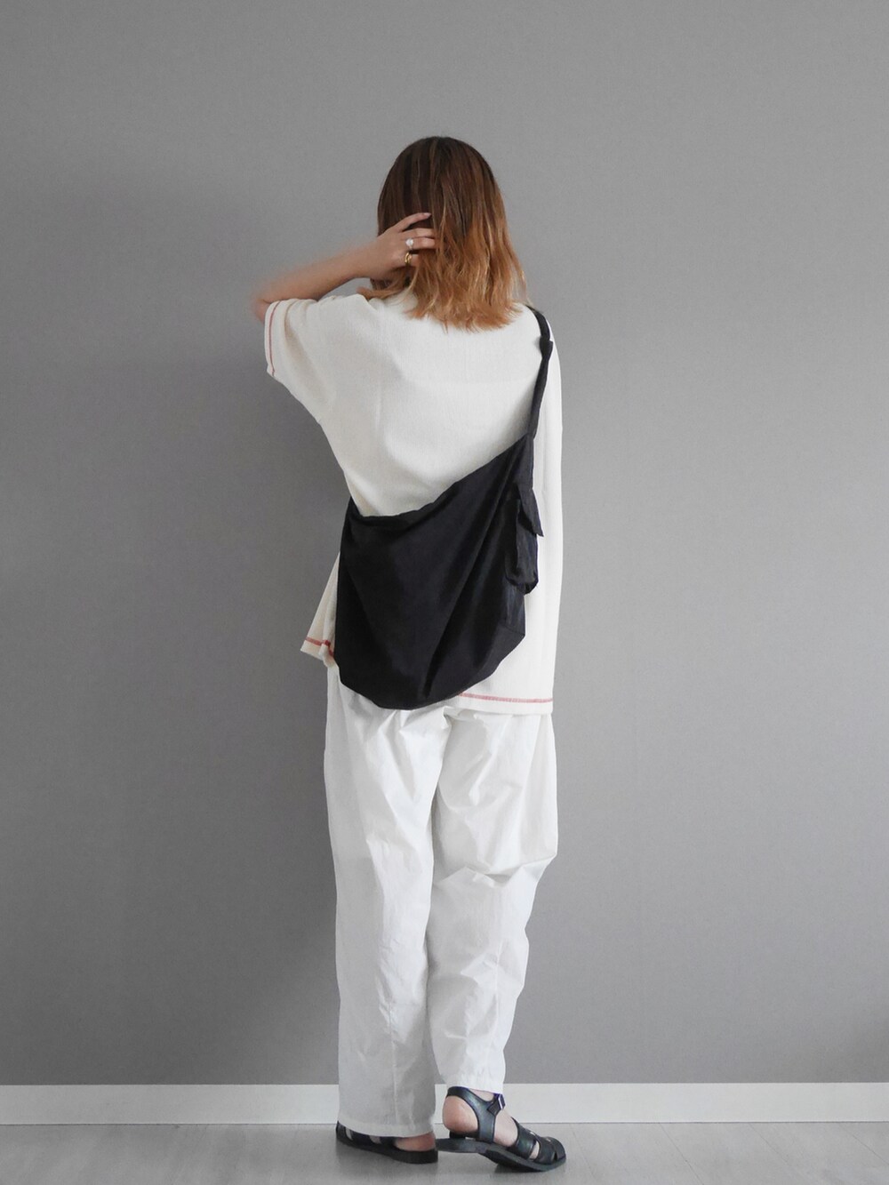 ホワイト系のTシャツ/カットソー、ホワイト系のその他パンツ、ブラック系のサンダルを着用したレディースの春コーディネートの2枚目の写真